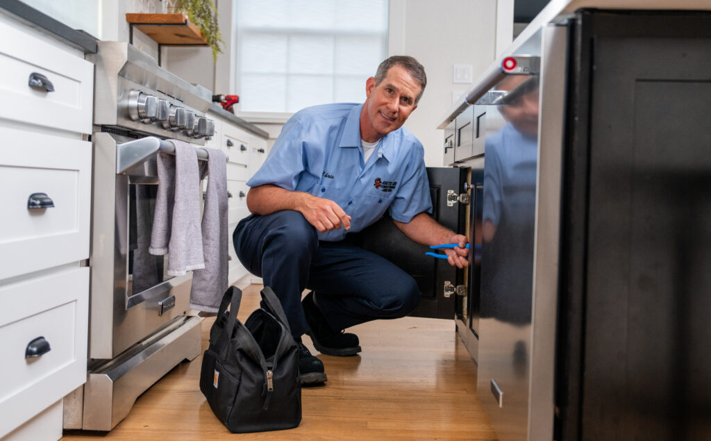 Local plumber working on kitchen sink