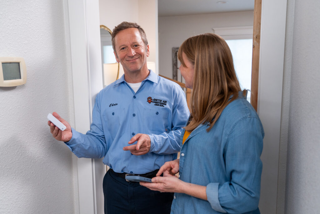 HVAC Tech Showing Customer Thermostat