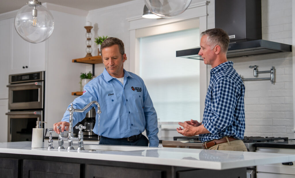 Plumber showing kitchen faucet to customer