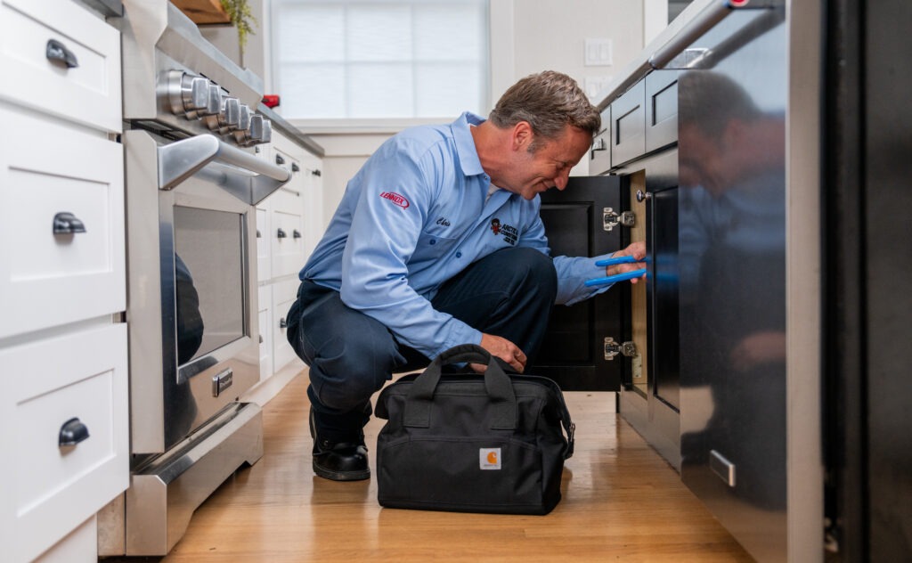 Local Plumber Working on Kitchen Plumbing