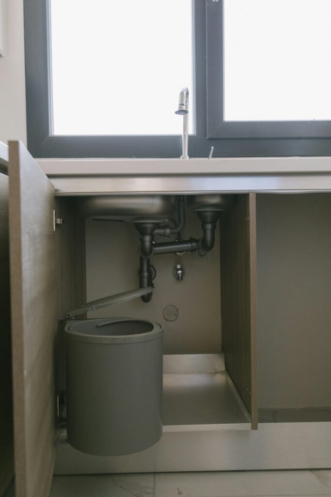 under-sink plumbing with bucket