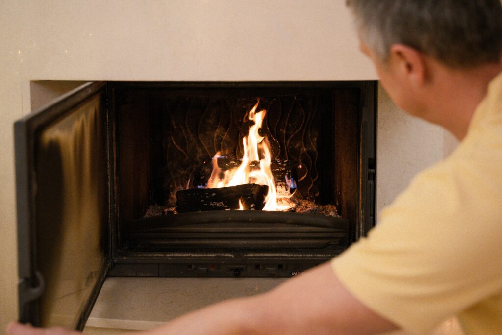 Man holding fireplace door open