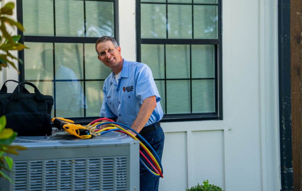 AC repair tech checking air conditioner